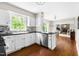 Well-lit kitchen featuring white cabinets, stainless steel appliances, and open access to living area at 109 Bessemer Pl, Durham, NC 27712