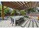 Outdoor patio with a dining table under a pergola, surrounded by greenery and hardscape with a basketball goal at 1101 Norris St, Raleigh, NC 27604