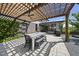 Outdoor patio featuring a dining table under a pergola, grill, hardscape and lush greenery surrounding the space at 1101 Norris St, Raleigh, NC 27604
