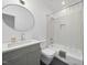 Stylish bathroom with modern vanity, oval mirror, and tiled shower-tub combination at 1101 Norris St, Raleigh, NC 27604