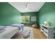 Cozy bedroom featuring bright green walls, hardwood floors, and abundant natural light at 1101 Norris St, Raleigh, NC 27604