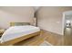 Neutral bedroom with hardwood flooring, a large bed and open doorway at 1101 Norris St, Raleigh, NC 27604