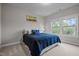 Cozy bedroom featuring a large window and comfortable blue bedding with accent pillows at 1104 Covered Bridge Trl, Chapel Hill, NC 27517
