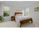 Cozy bedroom featuring multiple windows providing natural light, wood bed frame, and neutral decor at 1104 Covered Bridge Trl, Chapel Hill, NC 27517