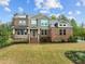 Beautiful two-story brick home with a green facade, a porch, and a professionally landscaped front yard at 1104 Covered Bridge Trl, Chapel Hill, NC 27517