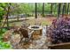 Outdoor fire pit area featuring a stone fire pit surrounded by wooden Adirondack chairs in a landscaped yard at 1104 Covered Bridge Trl, Chapel Hill, NC 27517