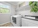 Well-lit laundry room with modern washer and dryer, sink, and ample counter space and storage at 1104 Covered Bridge Trl, Chapel Hill, NC 27517