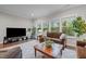Inviting living room featuring a plush sofa, bright windows with wooded views, and a stylish coffee table at 1104 Covered Bridge Trl, Chapel Hill, NC 27517