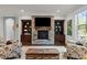 Inviting living room featuring a stone fireplace, custom built-ins, and hardwood floors at 1104 Covered Bridge Trl, Chapel Hill, NC 27517