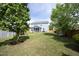 Large backyard with mature trees, lush lawn, a playhouse, playset, and screened porch at 1209 Redwood Valley Ln, Knightdale, NC 27545