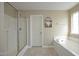 Modern bathroom featuring a glass shower, a soaking tub, and neutral-toned walls and tile at 1209 Redwood Valley Ln, Knightdale, NC 27545