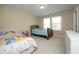 Bright bedroom featuring two beds, neutral paint, and natural light from the large window at 1209 Redwood Valley Ln, Knightdale, NC 27545