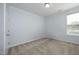 Empty bedroom with neutral carpet, light walls, and a window providing natural light at 1209 Redwood Valley Ln, Knightdale, NC 27545