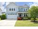 Charming two-story home featuring a well-manicured lawn and a two-car garage, all under a sunny blue sky at 1209 Redwood Valley Ln, Knightdale, NC 27545