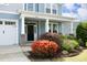 Inviting front entrance with colorful landscaping, black front door, and craftsman columns under a covered porch at 1209 Redwood Valley Ln, Knightdale, NC 27545