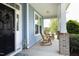 Welcoming front porch with rocking chairs, an elegant wreath, and a view of the home's light blue siding at 1209 Redwood Valley Ln, Knightdale, NC 27545