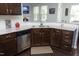 Kitchen featuring dark wood cabinets, granite countertops, stainless steel appliances, and a double sink at 1209 Redwood Valley Ln, Knightdale, NC 27545