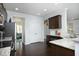 Open kitchen design with dark wood cabinets, granite countertops, stainless steel appliances, and hardwood floors at 1209 Redwood Valley Ln, Knightdale, NC 27545