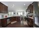 Spacious kitchen with dark wood cabinets, stainless steel appliances, granite countertops, and hardwood flooring at 1209 Redwood Valley Ln, Knightdale, NC 27545