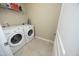 Functional laundry room with a washing machine, dryer, shelving, and a tiled floor at 1209 Redwood Valley Ln, Knightdale, NC 27545