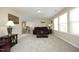 Spacious living room featuring a brown leather sofa, neutral walls, and multiple windows for lots of natural light at 1209 Redwood Valley Ln, Knightdale, NC 27545