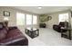 Comfortable living room with ample natural light, a brown leather sofa, a flat screen television, and neutral carpet at 1209 Redwood Valley Ln, Knightdale, NC 27545