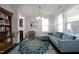 Cozy living room featuring a comfortable blue sofa, area rug, and bright natural light through the windows at 1209 Redwood Valley Ln, Knightdale, NC 27545