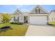 Charming home featuring stone accents, a well-maintained lawn, and a two-car garage at 1316 London Meadow Way, Fuquay Varina, NC 27526