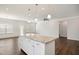 Open-concept kitchen featuring an island with granite countertops and stainless steel pendant lighting at 1316 London Meadow Way, Fuquay Varina, NC 27526