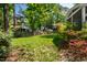View of a spacious backyard with a well-maintained lawn, surrounded by mature trees and wooden fencing at 1412 Amberton Ct, Raleigh, NC 27615