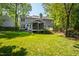 Expansive backyard features a lush lawn, mature trees, a screened porch and a rear deck at 1412 Amberton Ct, Raleigh, NC 27615