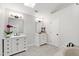 Bright bathroom with double vanity, mirrors, black hardware and travertine floors at 1412 Amberton Ct, Raleigh, NC 27615