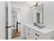 Modern bathroom featuring white cabinets, black hardware and light fixture, and gray towels at 1412 Amberton Ct, Raleigh, NC 27615