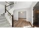 Staircase and hardwood floors lead into this airy foyer featuring modern décor and natural light at 1412 Amberton Ct, Raleigh, NC 27615