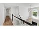 Upstairs hallway features wood floors, a chandelier, and a natural light window with a view at 1412 Amberton Ct, Raleigh, NC 27615