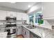 Bright kitchen features white cabinets, granite countertops, stainless steel appliances, and a window view at 1412 Amberton Ct, Raleigh, NC 27615