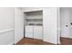 Convenient laundry closet with washer and dryer hookups with shelving for storage space at 1412 Amberton Ct, Raleigh, NC 27615