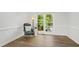 Neutral room with gorgeous wood floors and natural light from a large window with a chair at 1412 Amberton Ct, Raleigh, NC 27615