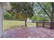 Large backyard with a deck and green, well-maintained lawn and mature trees at 145 Richmond Park Dr, Cameron, NC 28326