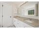Double sink bathroom featuring granite counters, white cabinets and updated lighting fixtures at 145 Richmond Park Dr, Cameron, NC 28326