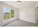 Carpeted bedroom featuring a large window and a closet door at 145 Richmond Park Dr, Cameron, NC 28326
