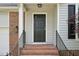 A close-up view of the black front door with brick steps and iron railings at 145 Richmond Park Dr, Cameron, NC 28326