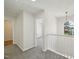 Well-lit upstairs hallway with gray carpet and white railing leading to bedrooms at 145 Richmond Park Dr, Cameron, NC 28326