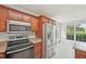 Kitchen with stainless appliances, wood cabinets, eat-in area, and large windows at 145 Richmond Park Dr, Cameron, NC 28326