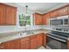 Close-up on kitchen with stainless appliances and warm wood cabinetry at 145 Richmond Park Dr, Cameron, NC 28326