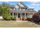 Charming two-story brick home featuring a welcoming front porch and lush landscaping at 192 Crestdale Dr, Clayton, NC 27520