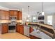 Well-lit kitchen featuring stainless steel appliances, granite countertops, and warm wood cabinets at 192 Crestdale Dr, Clayton, NC 27520