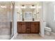 Bathroom featuring a tiled shower, double sink vanity, and updated fixtures at 2027 Hayes Ln, Holly Springs, NC 27540