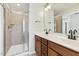 Bathroom with a tiled shower, double sink vanity, and modern fixtures at 2027 Hayes Ln, Holly Springs, NC 27540