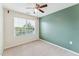 Bedroom with ceiling fan, window and accent wall painted teal at 2027 Hayes Ln, Holly Springs, NC 27540